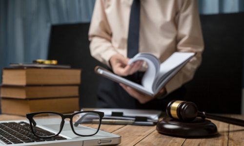 Business lawyer working hard at office desk workplace with book and documents.